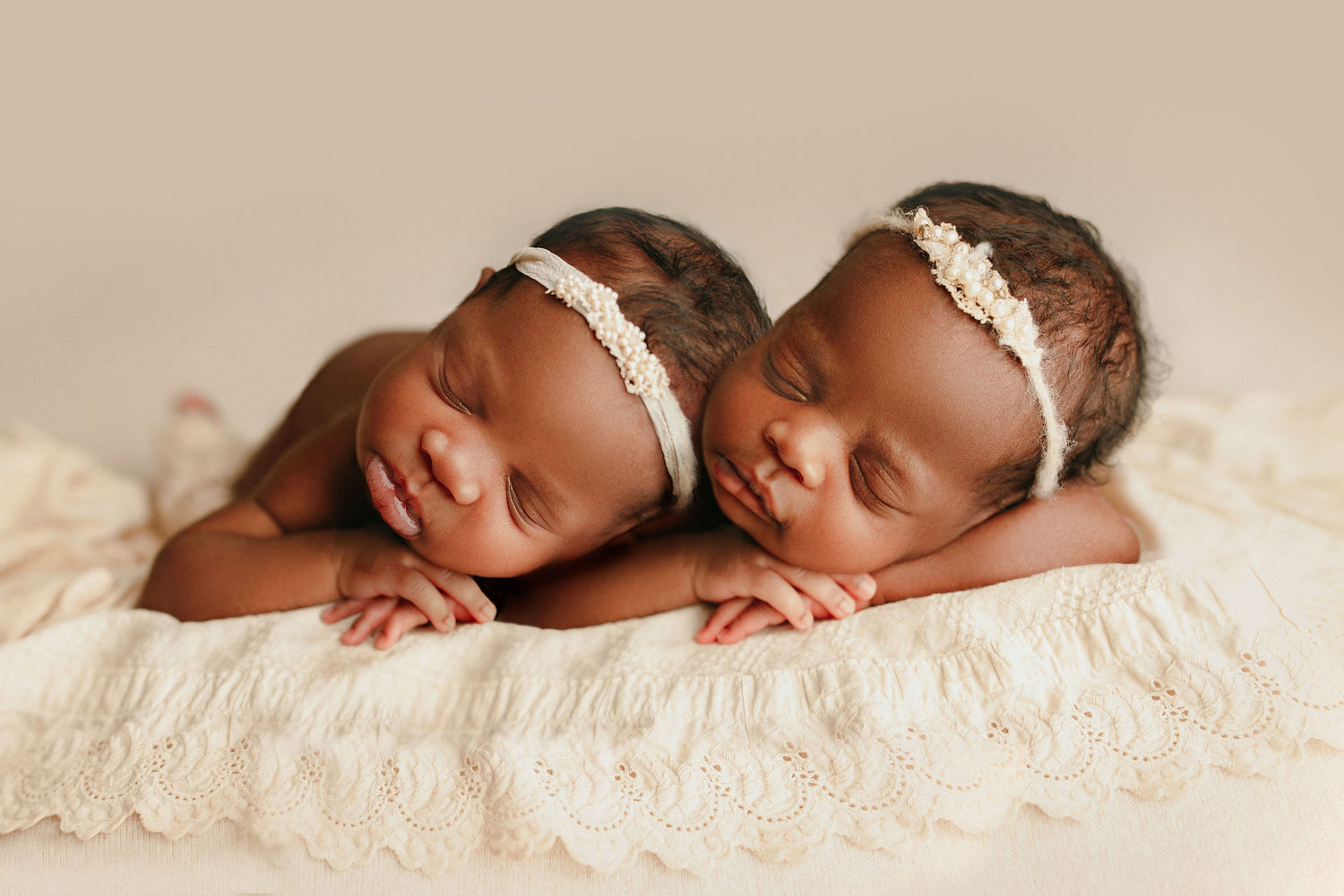 Head on hands posed twin girl studio newborn photoshoot